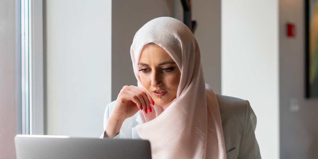 Woman wearing a hijab working on her laptop