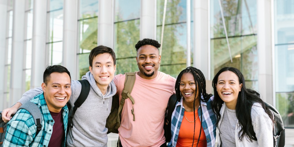 University students huddled together smiling for the camera - the Starrez community