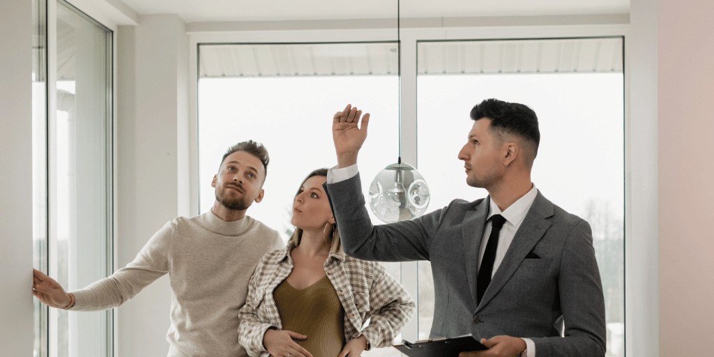 Estate agent showing couple around a living space for rent