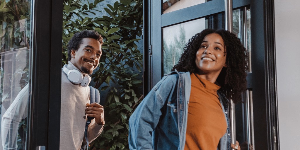 Young woman and man entering a building