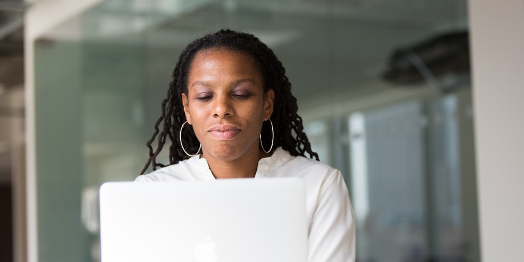 Woman looking down at her laptop as she works