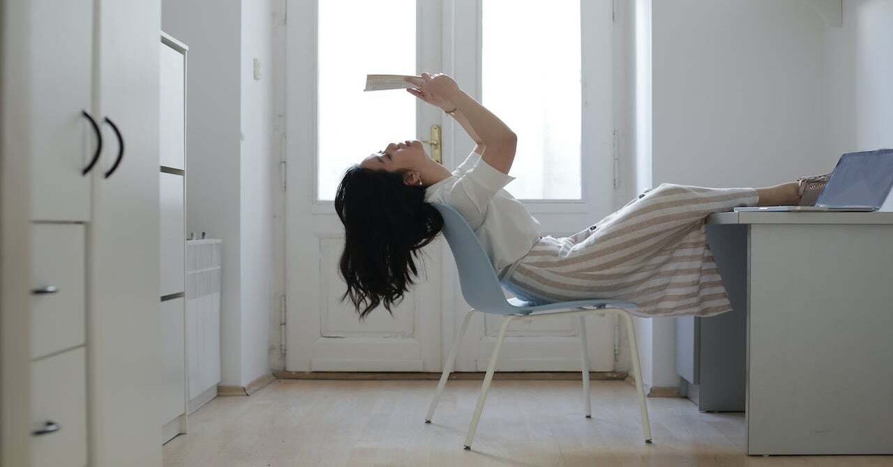 student reading a book relaxing in room