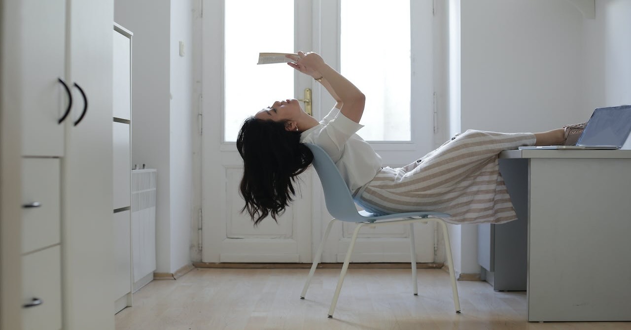 student reading a book relaxing in room